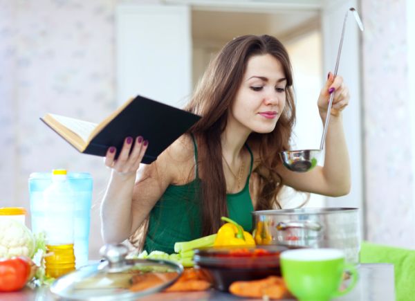 Donna cucina mentre legge