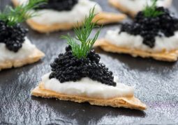 Cracker con formaggio cremoso e caviale nero per la Vigilia di Natale