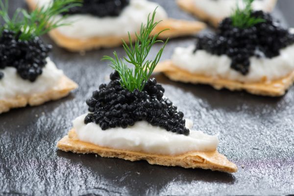 Cracker con formaggio cremoso e caviale nero per la Vigilia di Natale